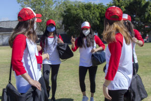 Teenage girls on baseball team wearing masks and preparing for outdoor workout