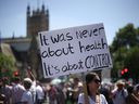 A woman holds a placard during an anti-lockdown and anti-vaccine protest, amid the coronavirus disease (COVID-19) pandemic, near the Houses of Parliament, London, Britain, June 14, 2021. REUTERS/Henry Nicholls ORG XMIT: GDN